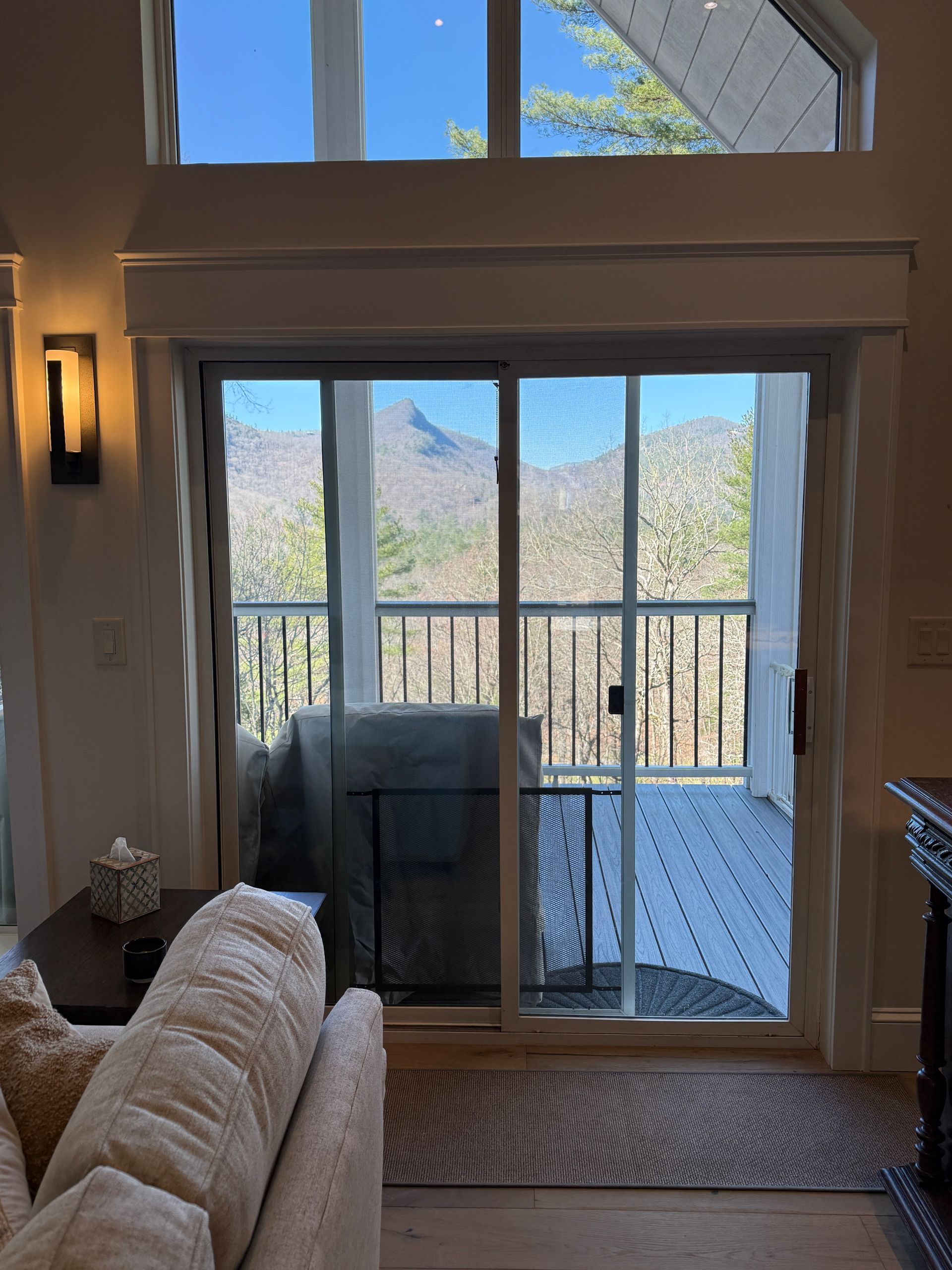 Living room sliding glass doors open to a deck with mountain views and a grill outside.
