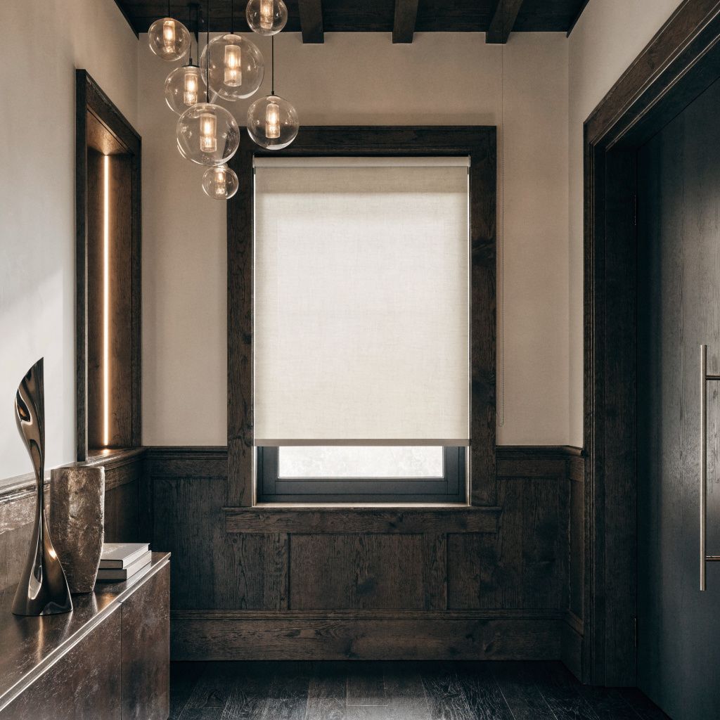 Modern hallway with dark wood trim, a window with a roller shade, and a hanging glass globe chandelier.