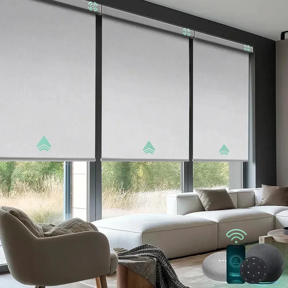Modern living room with white sofas and large windows covered by light gray roller blinds