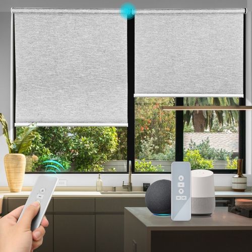 Hand holding a remote toward motorized window shades in a bright kitchen, with a small smart speaker on the counter