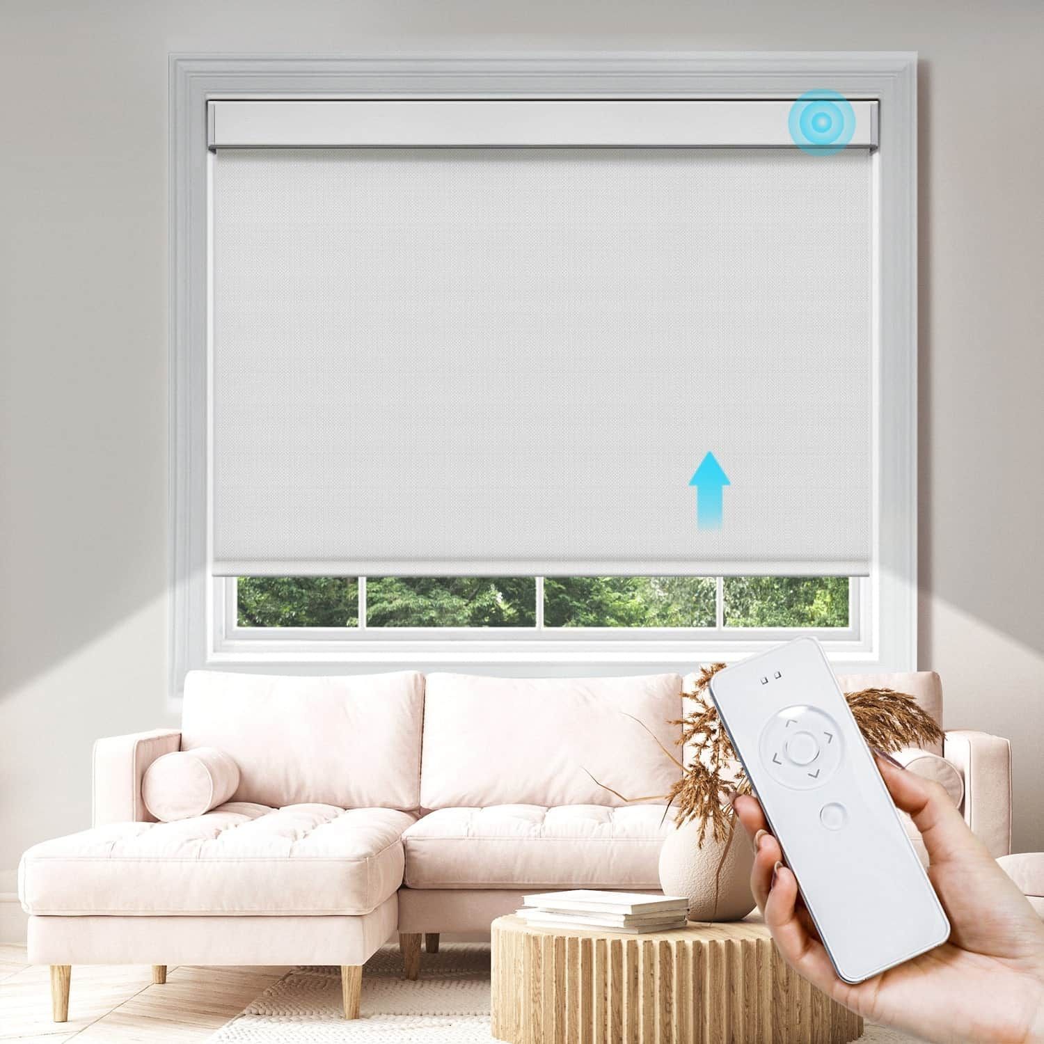 Living room with closed white roller blind being raised by a remote control