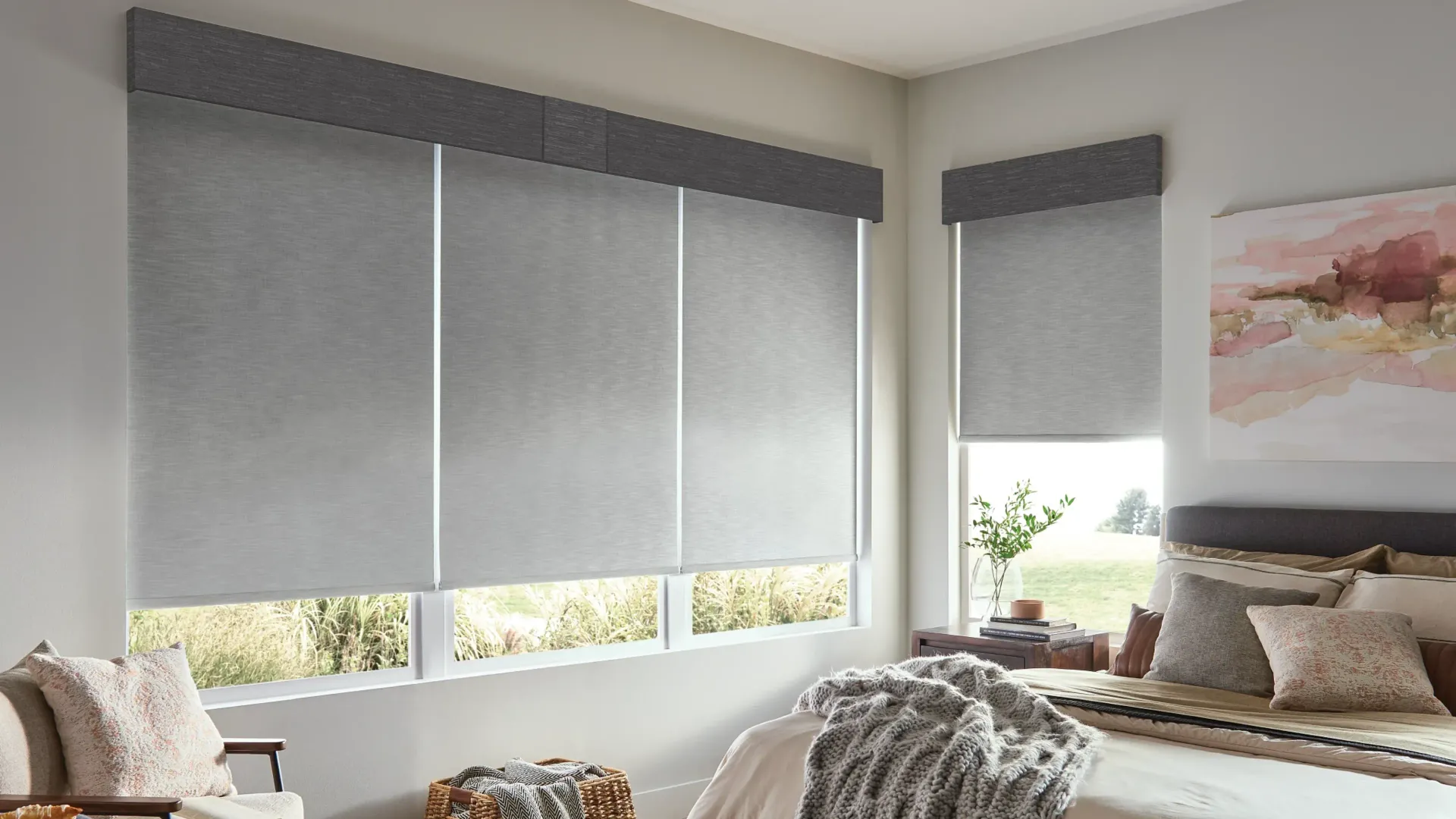 Bright bedroom with gray window shades, bed, and a pastel wall painting.