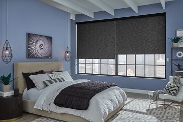 Modern bedroom with blue walls, gray bed, large window shades, and wall art