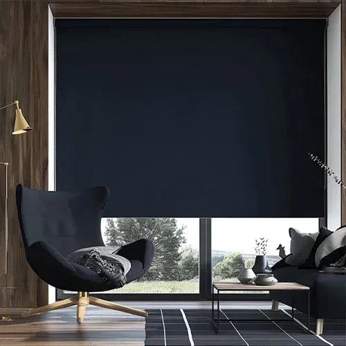Modern living room with dark armchair, sofa, coffee table, and large window covered by a black blind