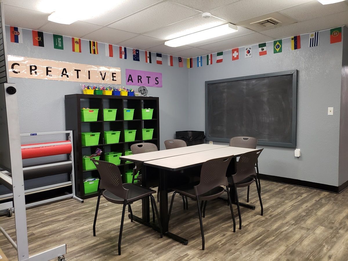 A classroom at Unified Residential Homes with a table and chairs and a blackboard.