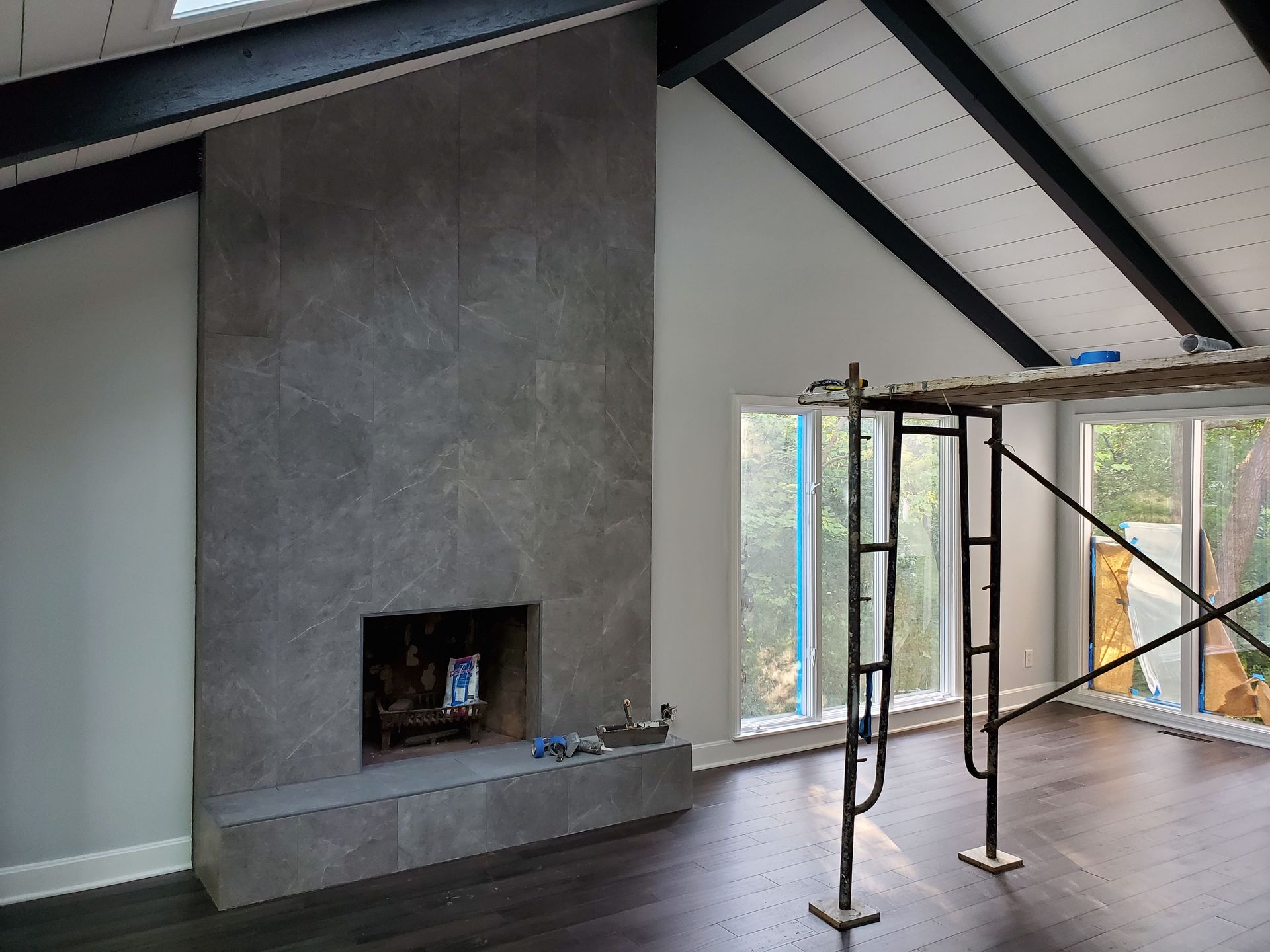 A living room with a fireplace and scaffolding in front of it