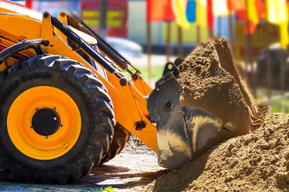 A Yellow Bulldozer Is Moving Dirt On A Construction Site — Ian Brown Sand Supplies and Tipper Hire In Port Macquarie, NSW