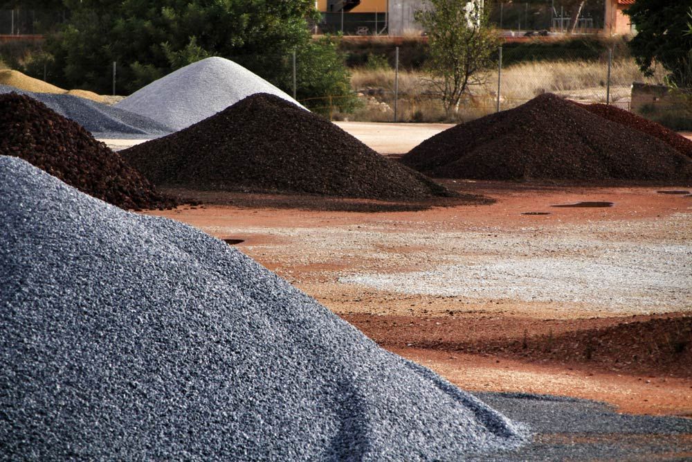 A Pile Of Gravel Is Sitting In The Middle Of A Field — Ian Brown Sand Supplies and Tipper Hire In Port Macquarie, NSW