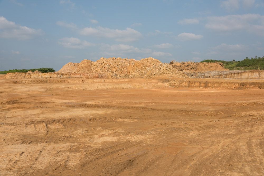 A large pile of dirt is Sitting in the Middle of a dirt field — Ian Brown Sand Supplies and Tipper Hire In Wauchope, NSW