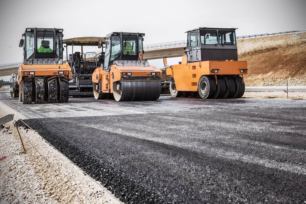 Three Asphalt Rollers Are Working On A Road Under Construction — Ian Brown Sand Supplies and Tipper Hire In Wauchope, NSW