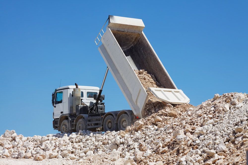 A Dump Truck Is Dumping Rocks Into A Pile Of Rocks — Ian Brown Sand Supplies and Tipper Hire In Port Macquarie, NSW