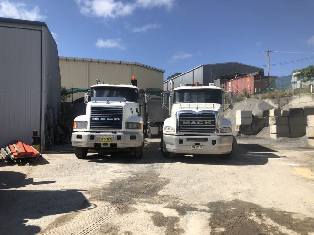 Two White Mack Trucks Parked Side by Side on the Port Macquarie