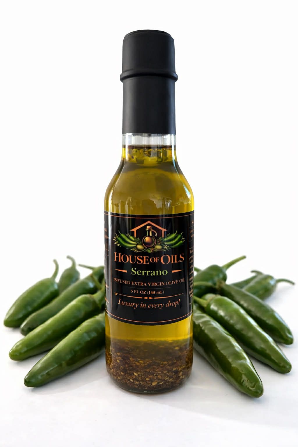 Bottle of jalapeño oil surrounded by green jalapeño peppers on a white background