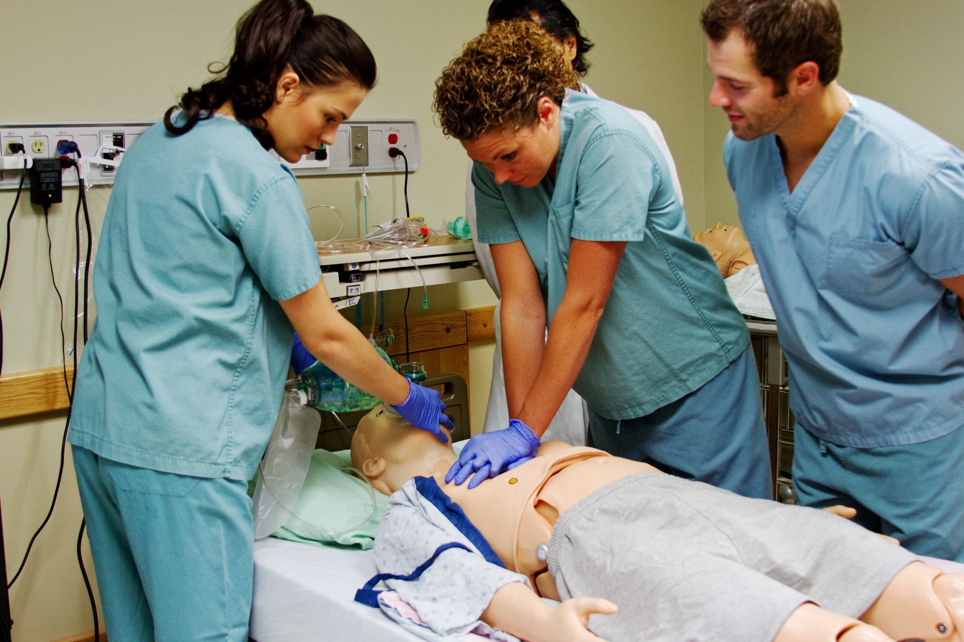 Medical staff performing CPR on a patient on a hospital bed