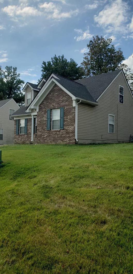 A white truck is parked in front of a large house