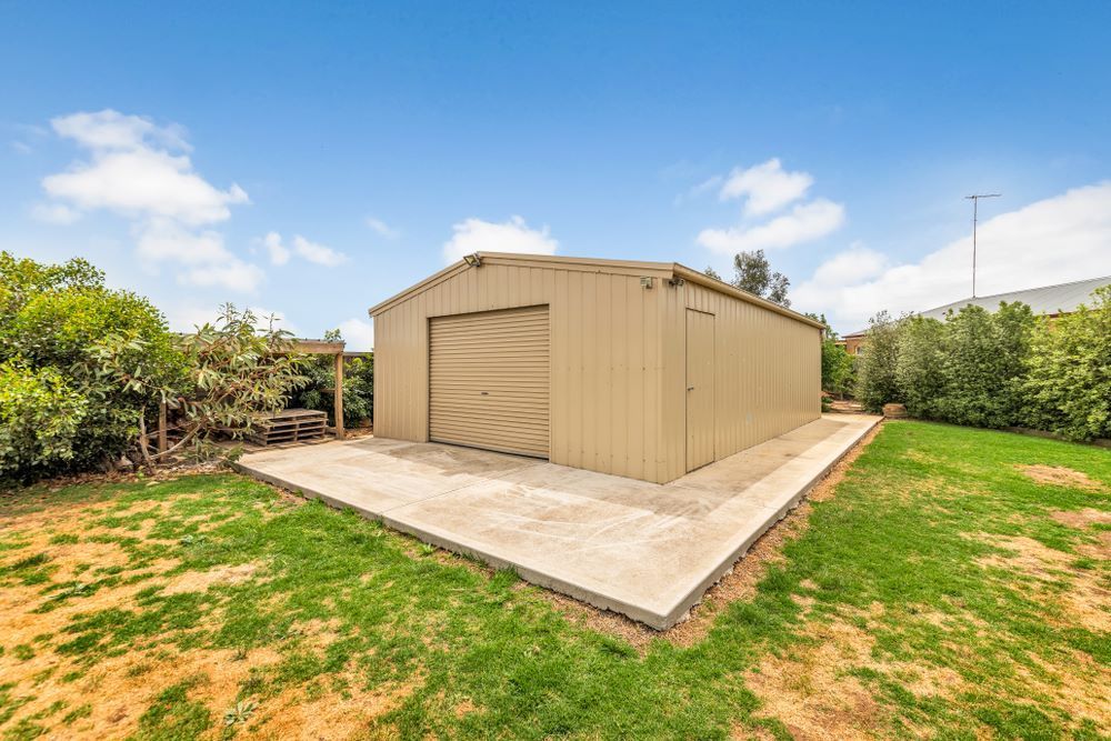 A Large Metal Garage is Sitting in the Middle of a Lush Green Field — Kingaroy Self Storage Sheds in Kingaroy, QLD
