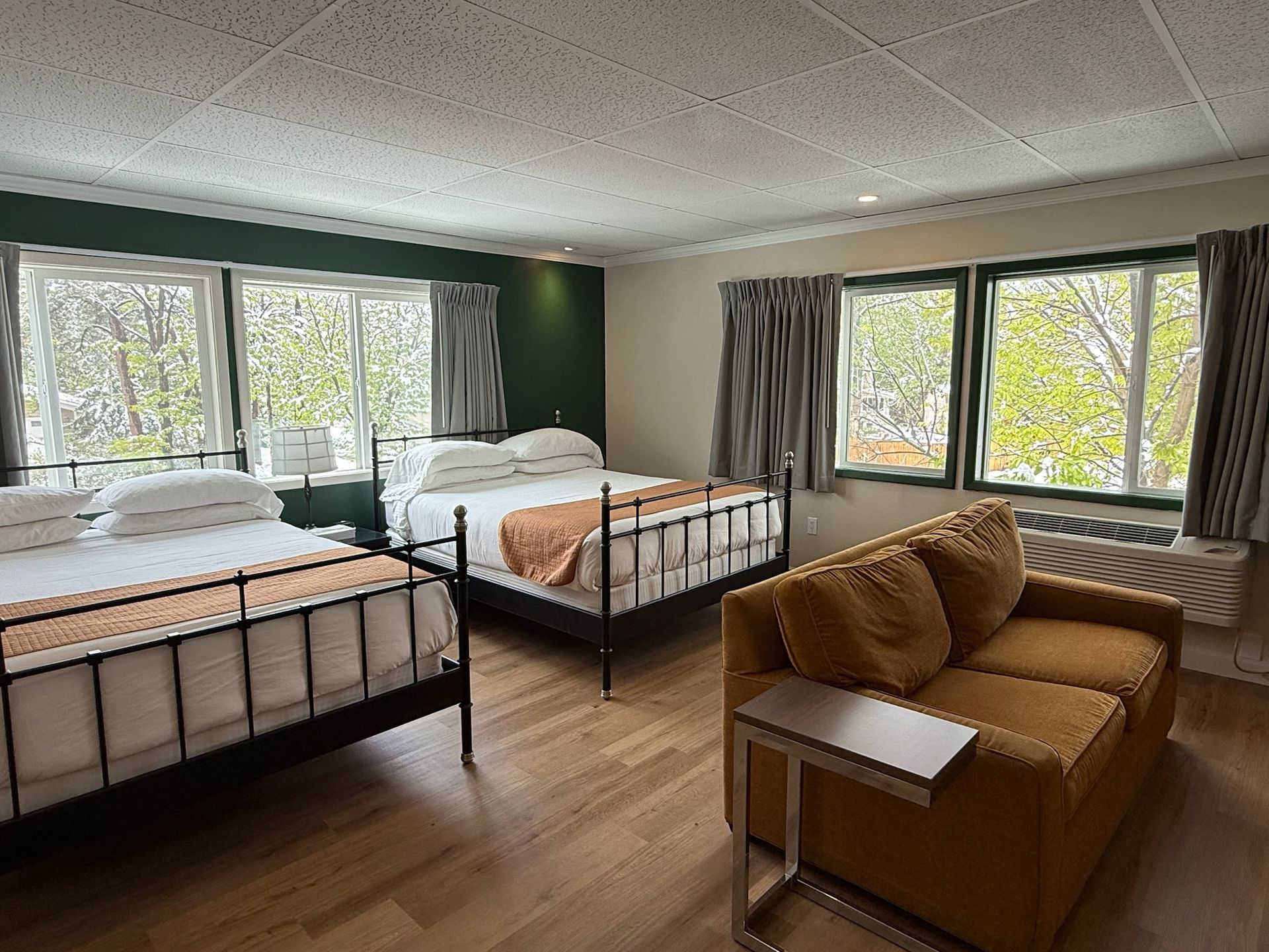 A hotel room with two beds , a couch , and a coffee table.
