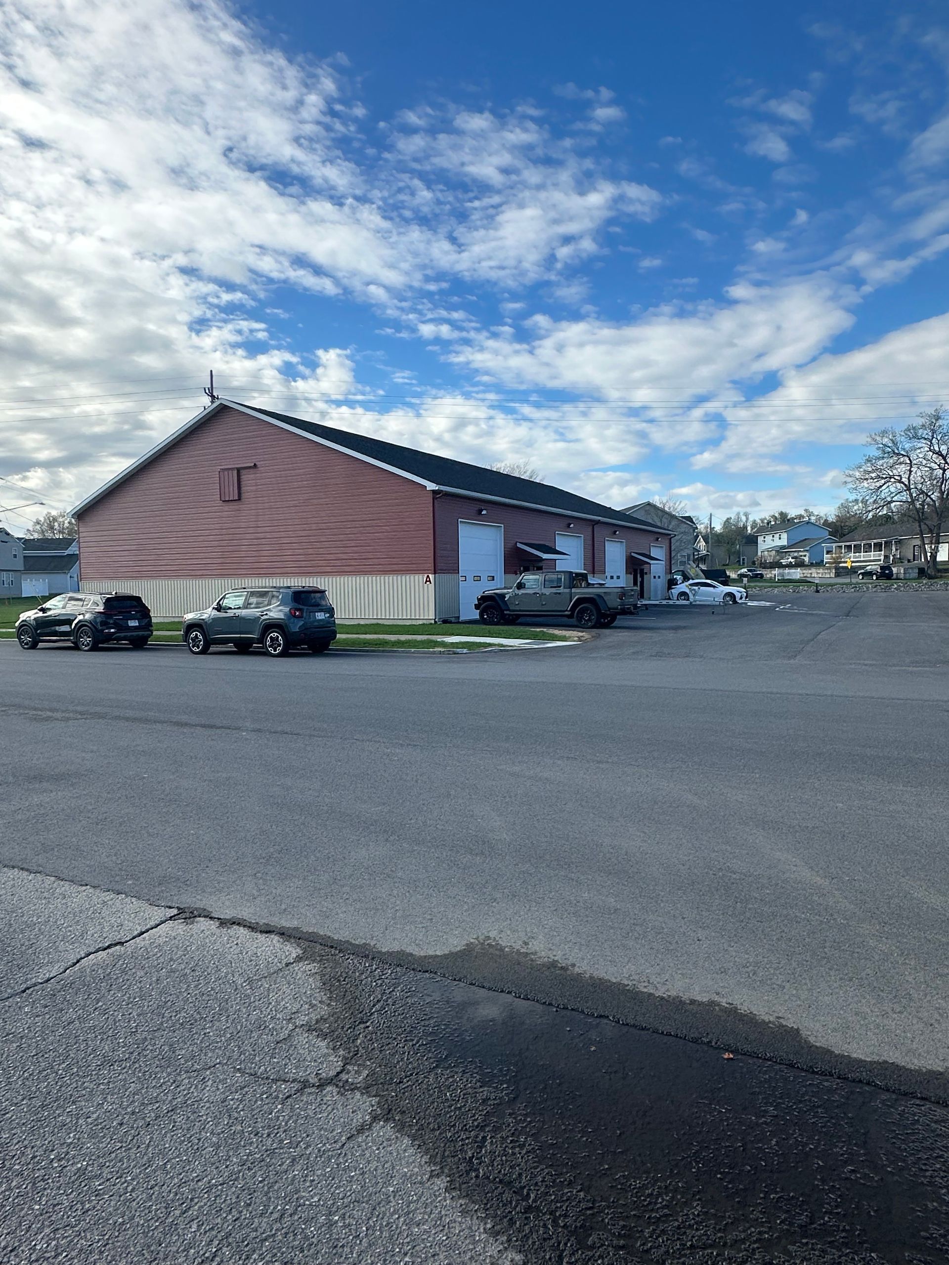 A row of garage doors are lined up in a parking lot.