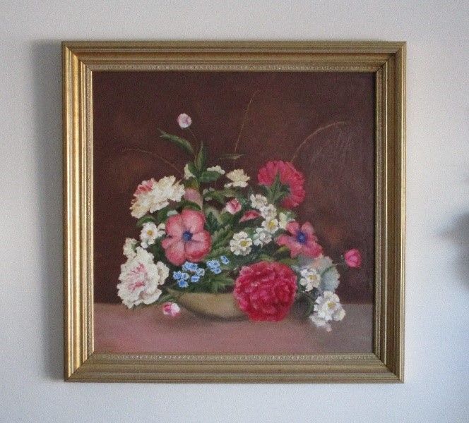 An oil painting of a vibrant bouquet of pink, red, and white flowers in a bowl, set against a dark, muted background.