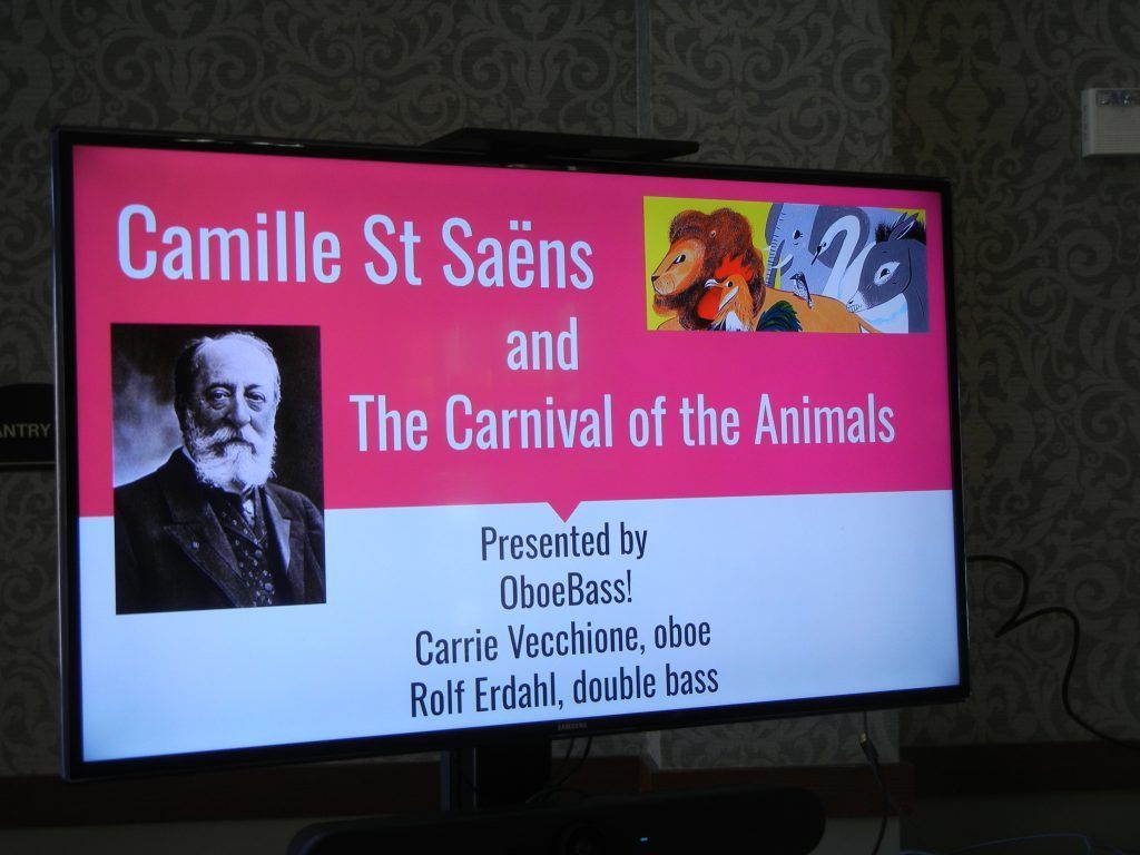 A presentation slide about Camille Saint-Saëns and The Carnival of the Animals, featuring his photo and the OboeBass! duo.