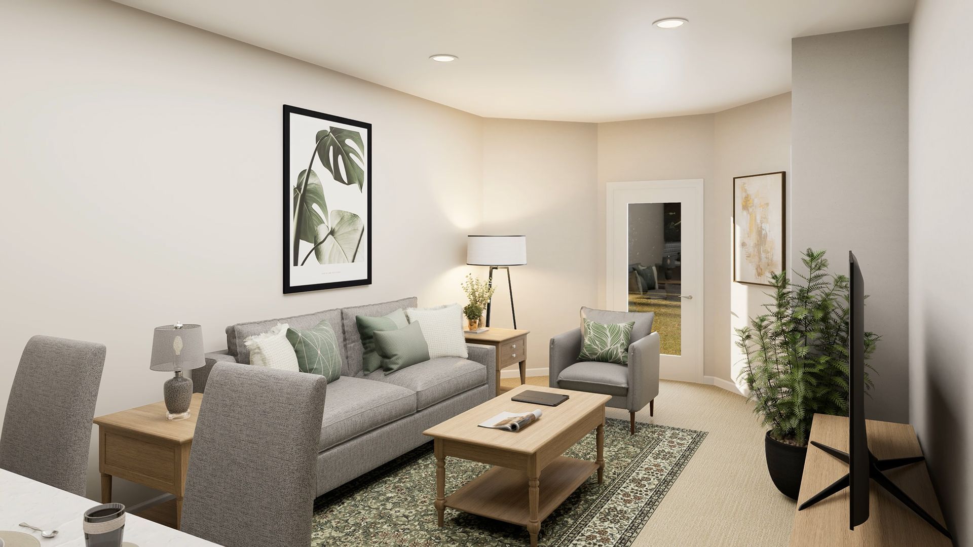 A living room featuring a grey sofa with green pillows, a coffee table, a matching armchair, and a houseplant by a TV.