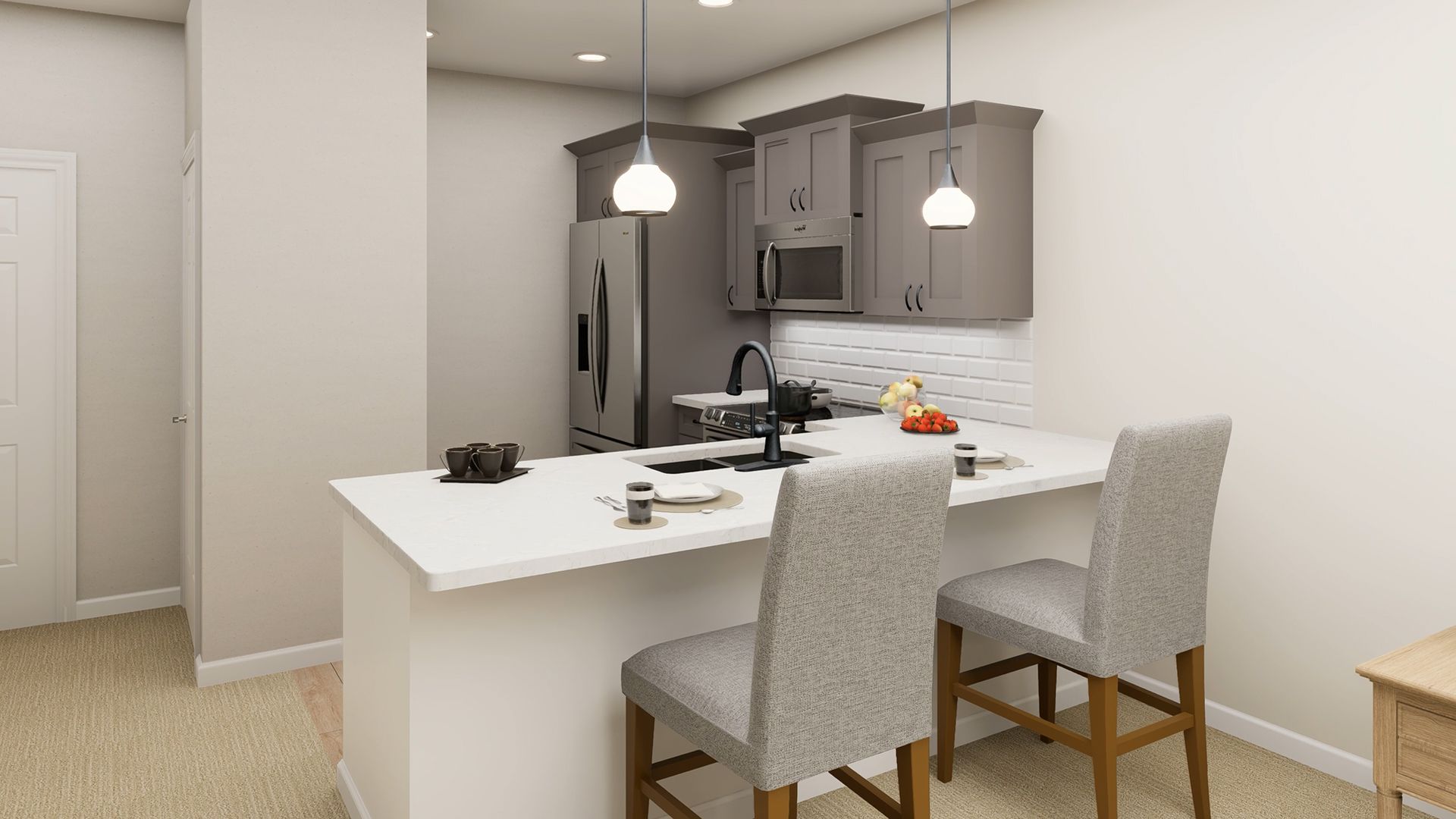 A kitchen with grey cabinets, white countertops, a breakfast bar with two grey chairs, and two hanging pendant lights.