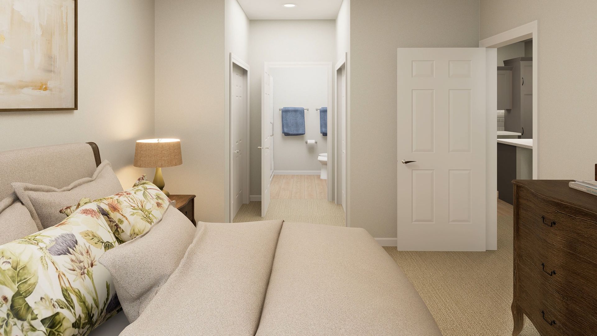A bedroom with a tan bed, a bedside lamp, a hallway leading to a bathroom, a white door, and a wooden dresser.