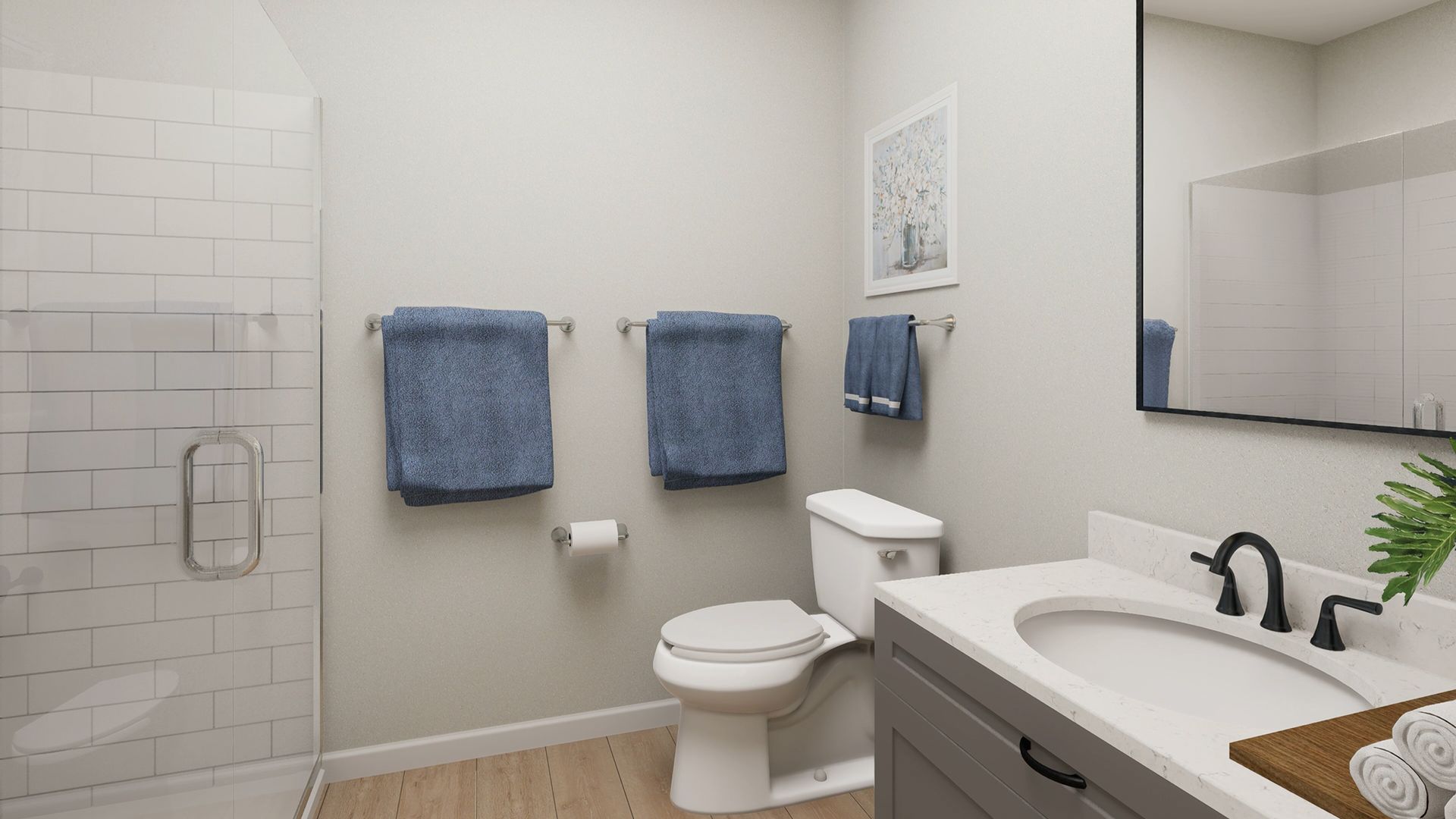Modern bathroom with a gray vanity, white subway tile shower, toilet, and two blue towels hanging on the wall.