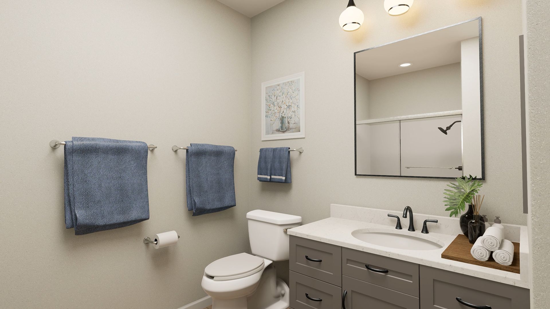 A neutral-toned bathroom featuring a gray vanity with a white countertop, toilet, wall-mounted towels, and a mirror.
