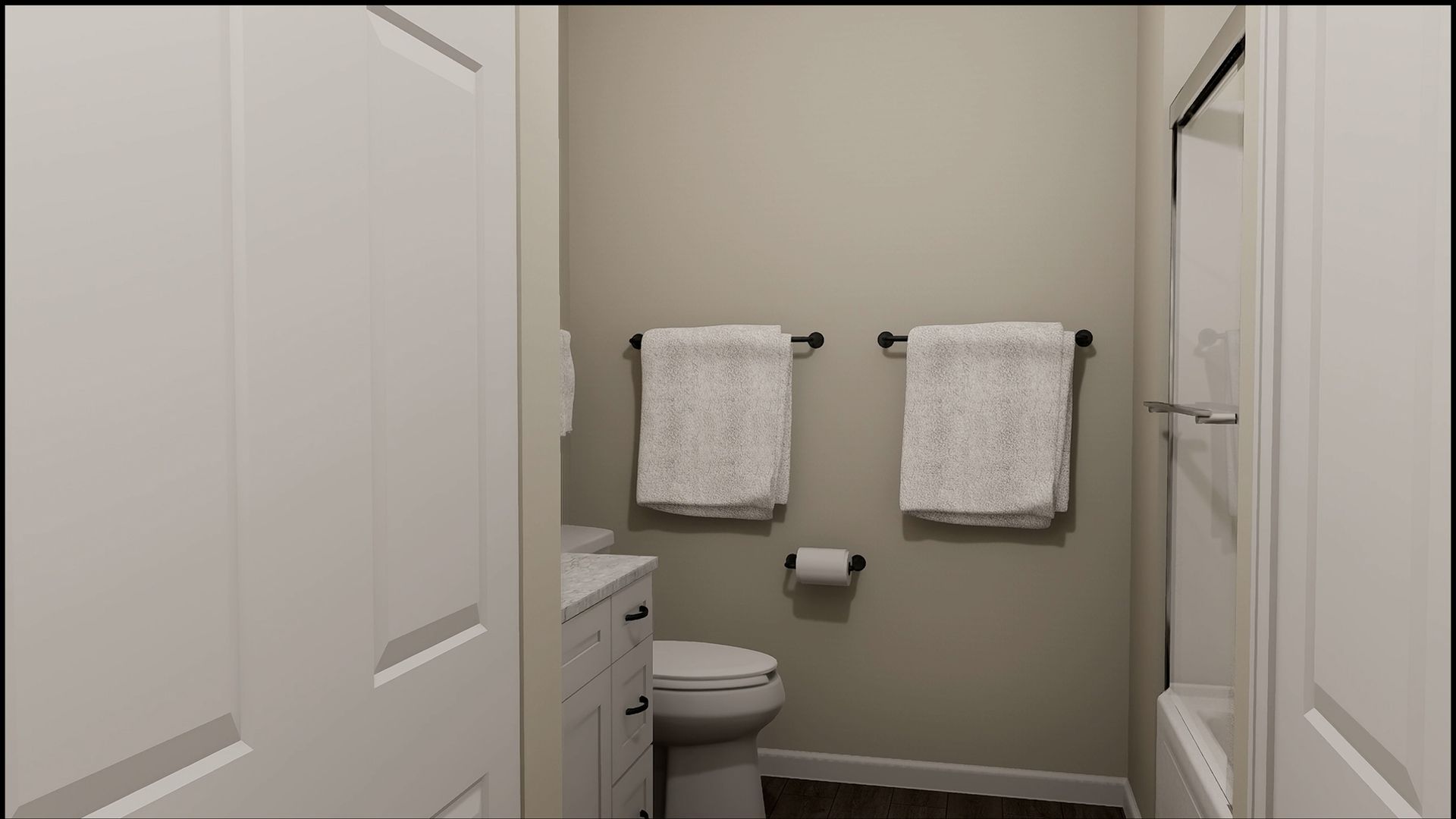 A bathroom with a white vanity, a toilet, and two white towels hanging on the wall above the toilet.