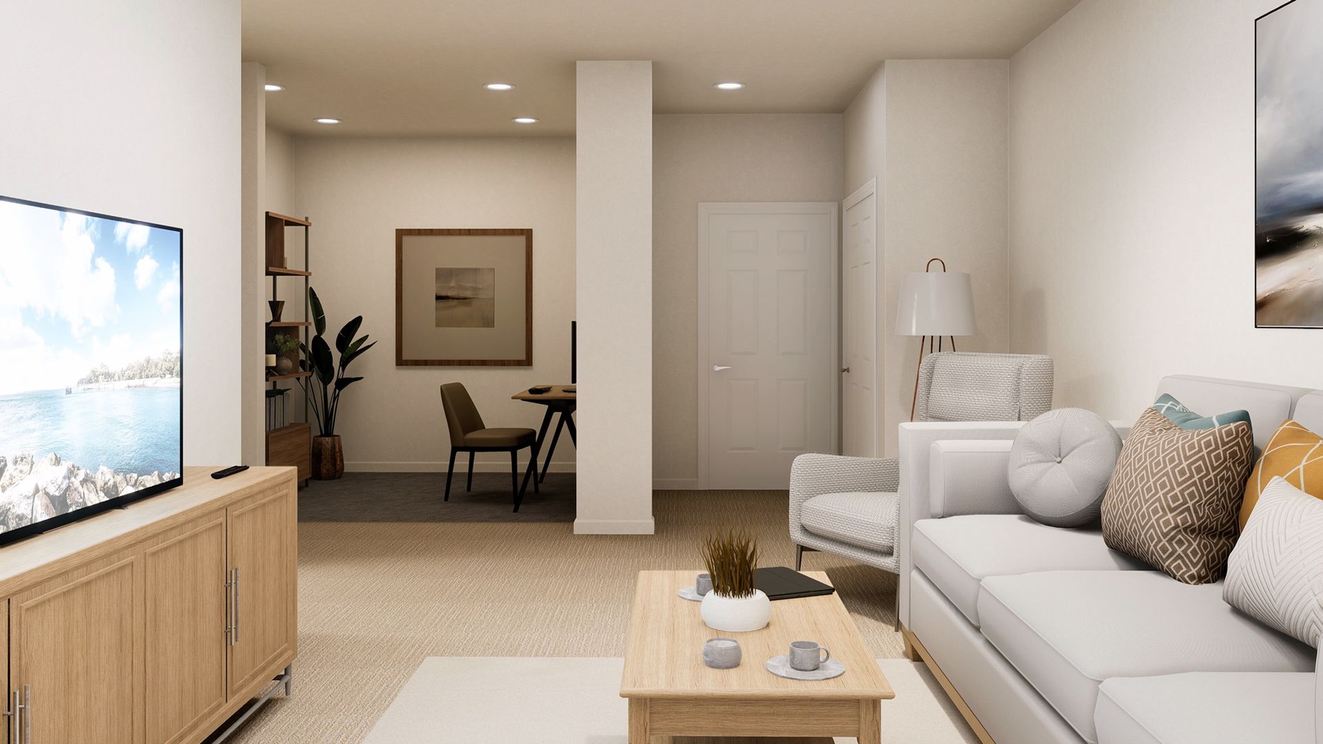 A bright living room features a sofa with decorative pillows, a coffee table, a television, and a separate study area.