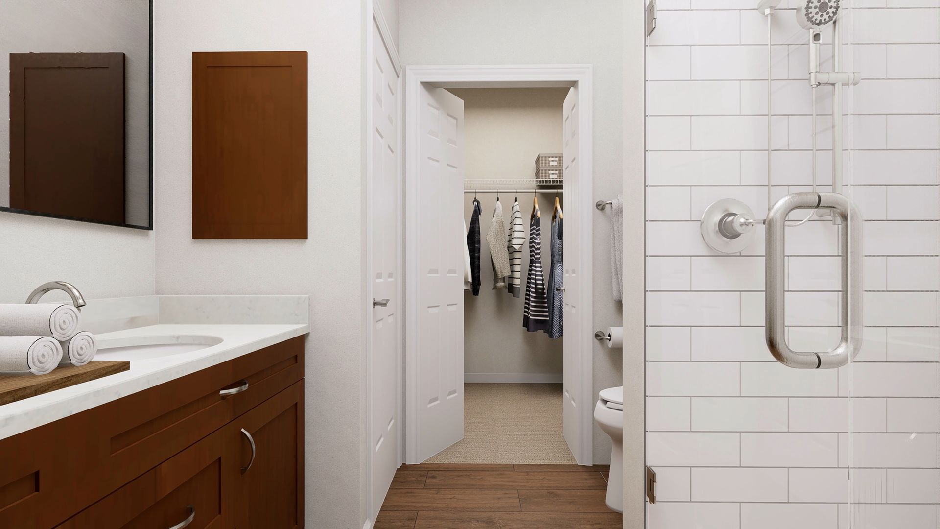 Modern bathroom with a wooden vanity, tiled shower, and open doorway to a walk-in closet.