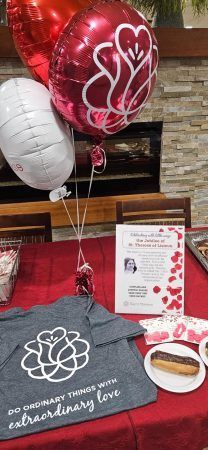 Balloons and a t-shirt with a floral logo reading 