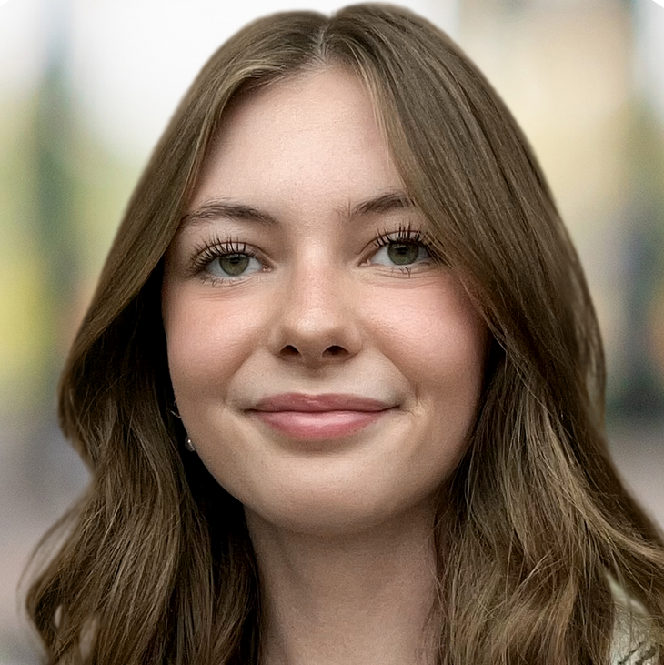 A young woman with long brown hair is smiling for the camera.