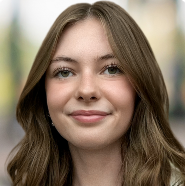 A young woman with long brown hair is smiling for the camera.