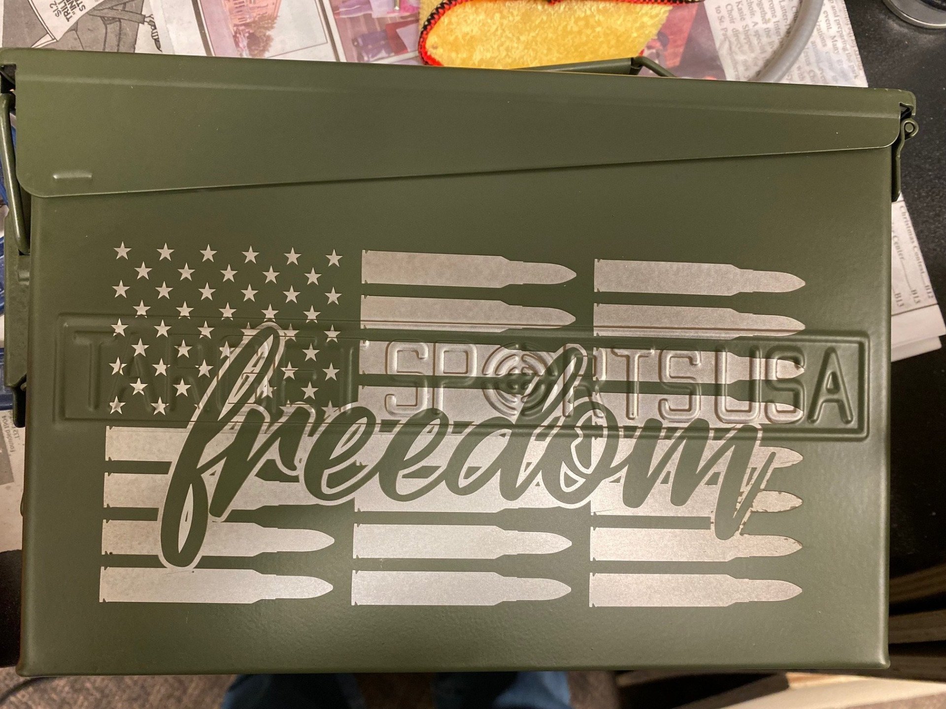 Olive green box with a distressed American flag design and the word “freedom” across the front.