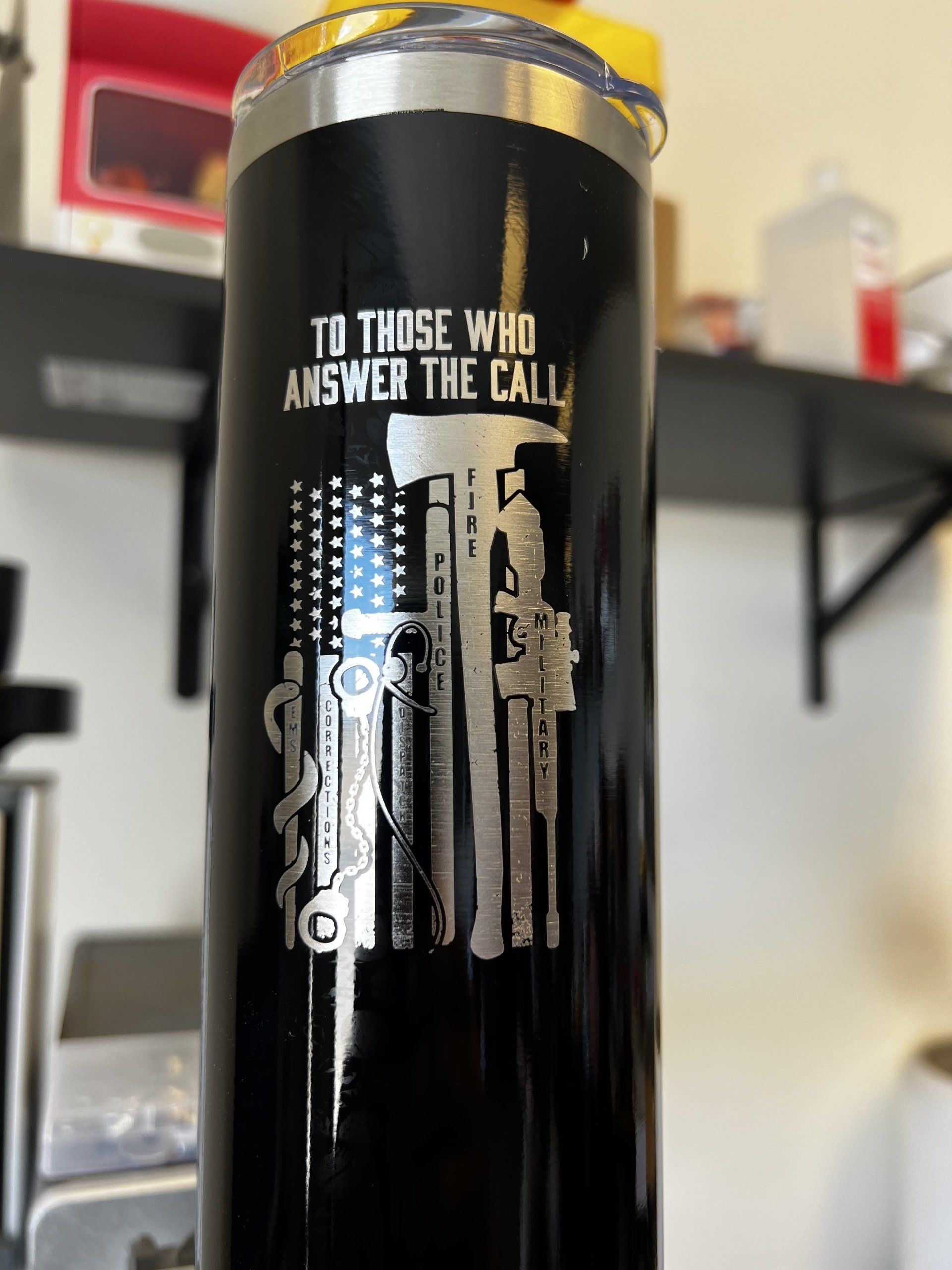 Black tumbler with “TO THOSE WHO ANSWER THE CALL” and a police/firefighter graphic on a shelf