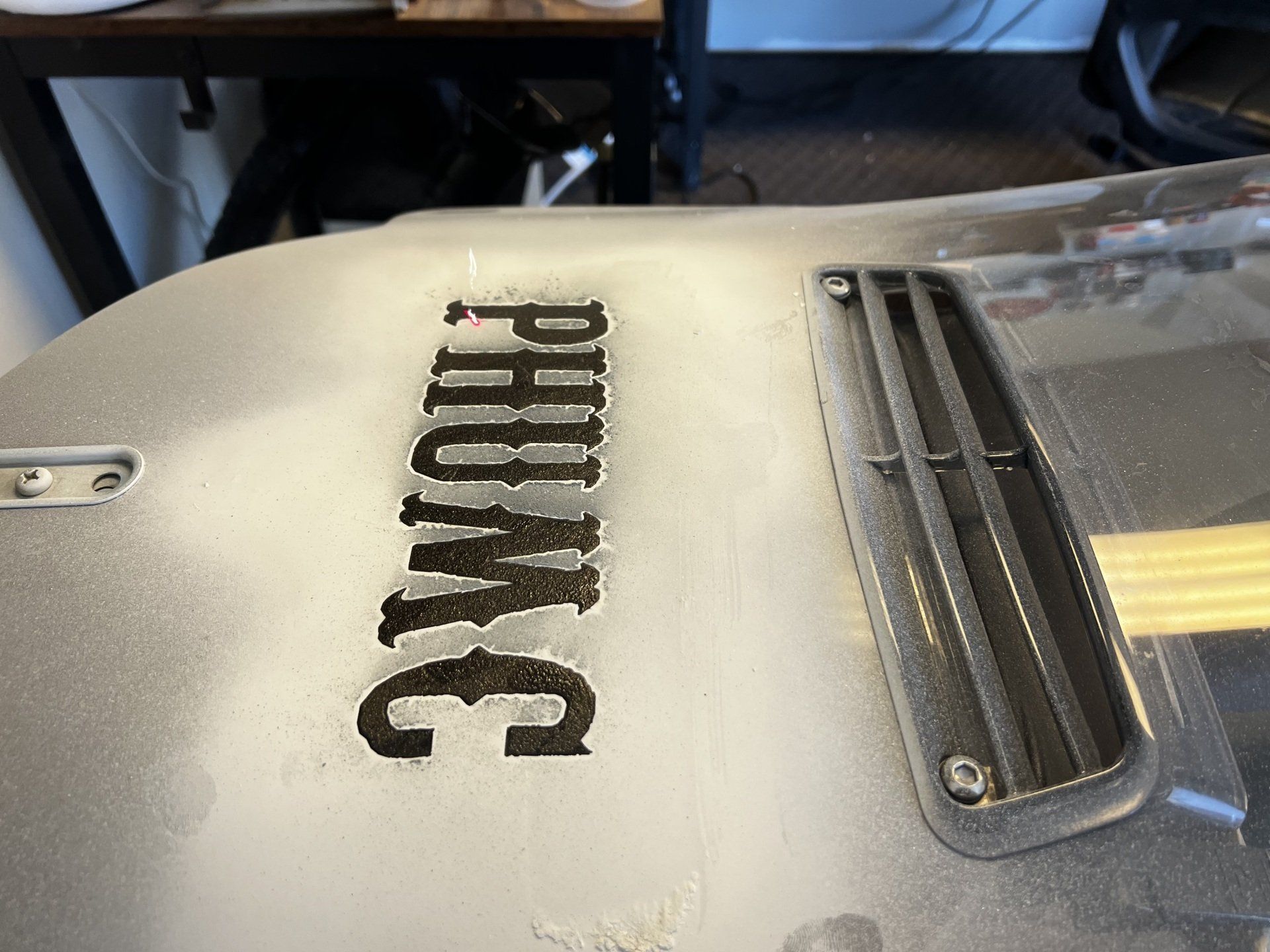 White curved metal appliance with black “PARKING” stencil and a chrome vent grille on top.