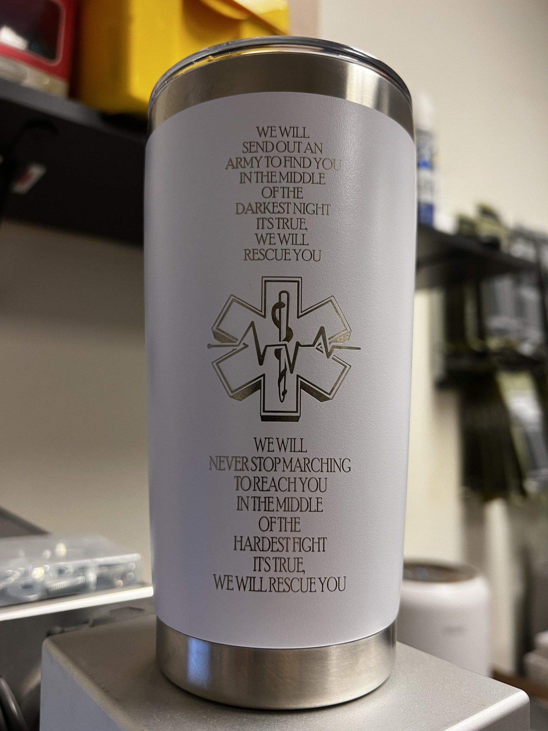 Cylindrical silver container with a white label and a black medical-style cross symbol