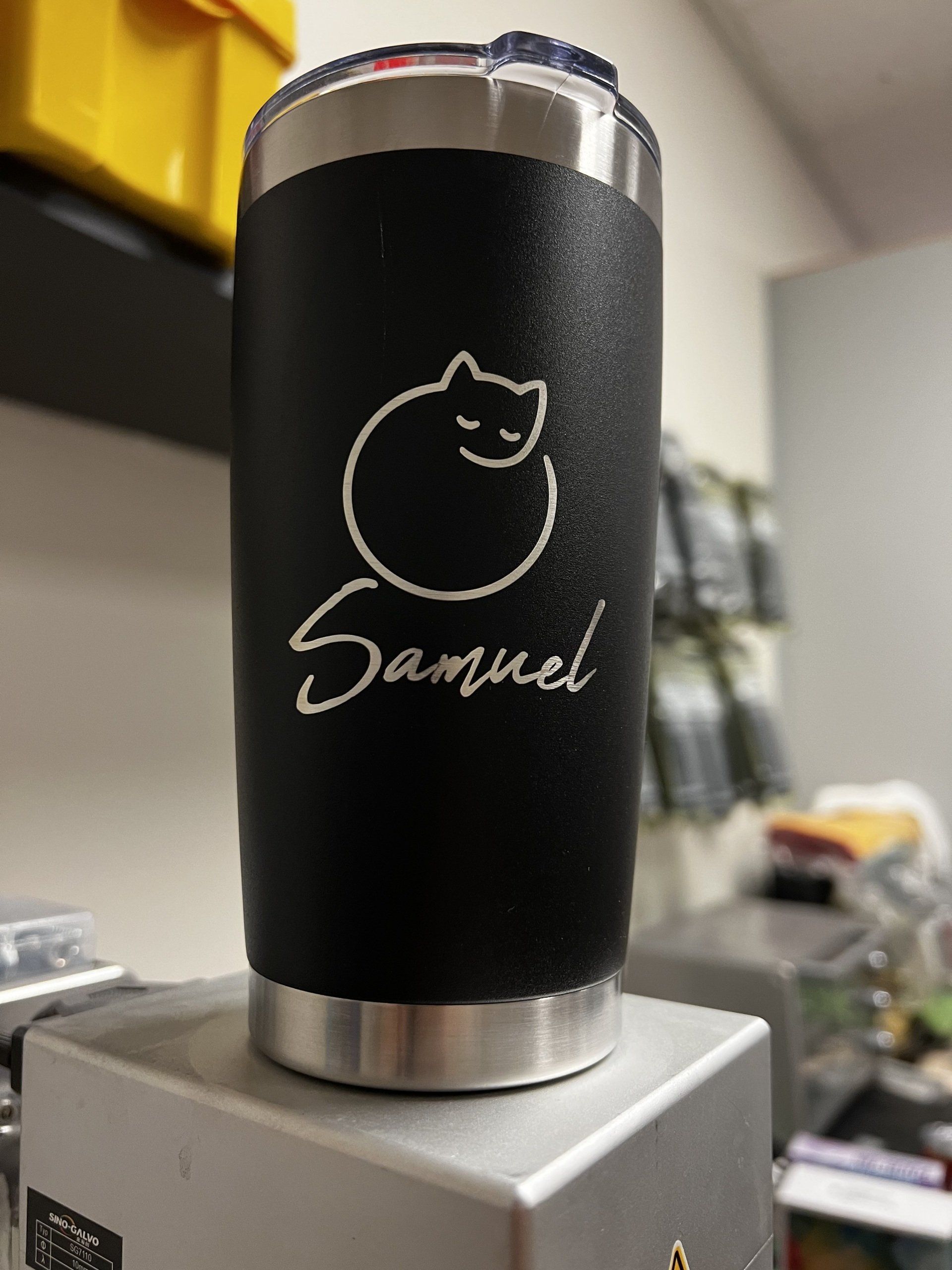 Black insulated tumbler with cat outline and “Samuel” on a countertop