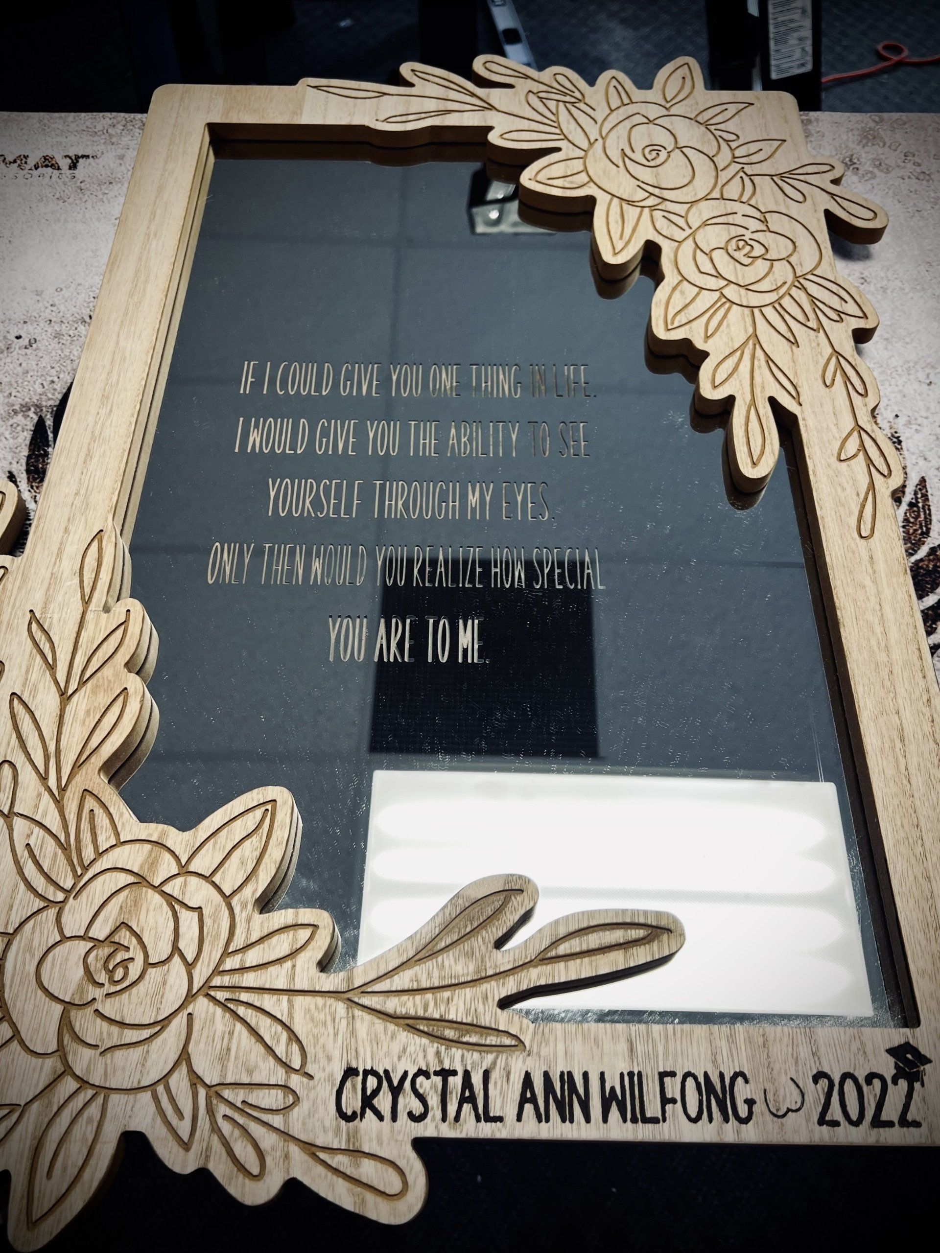Wooden framed mirror with floral design and engraved inscription. 