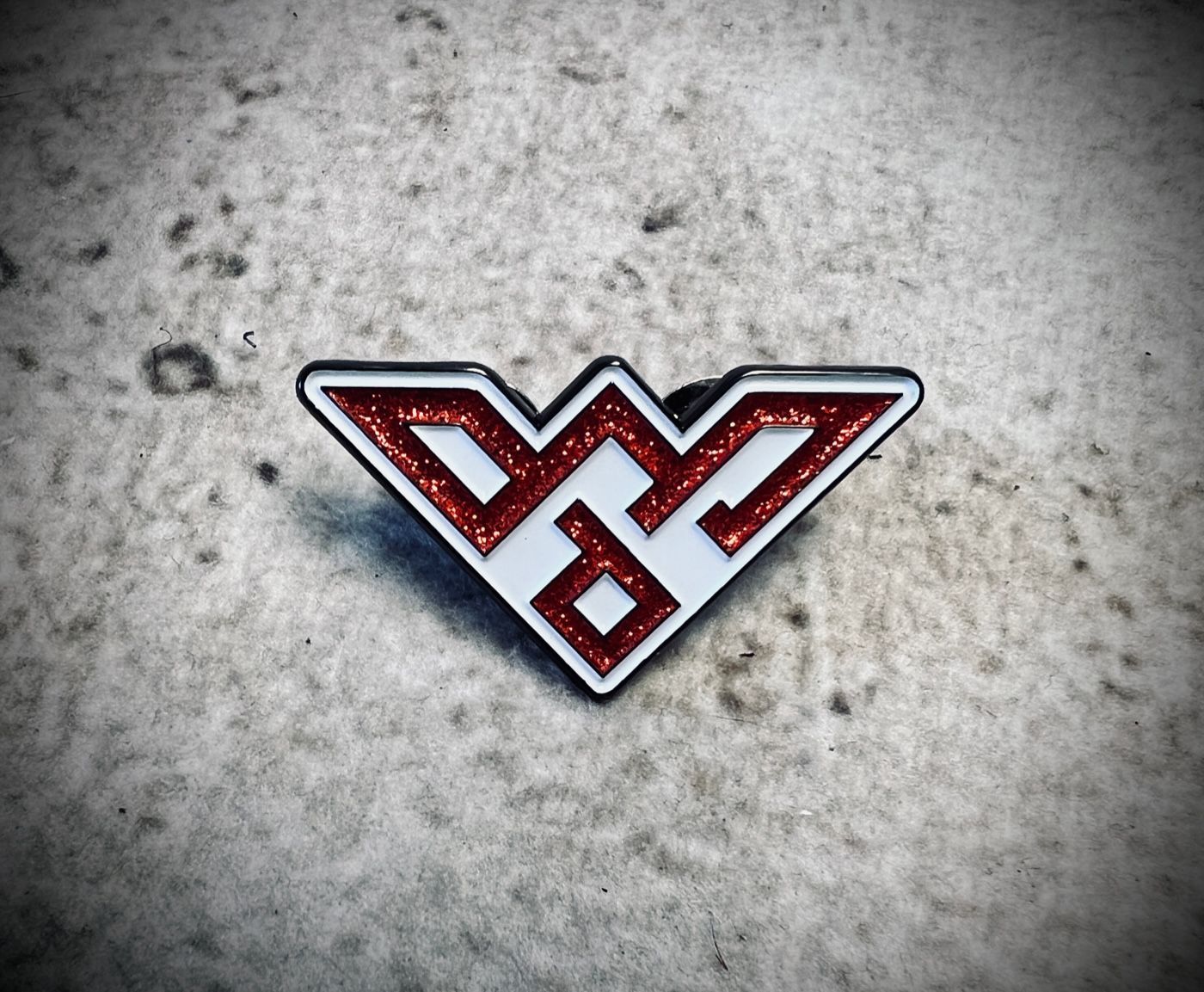 Red and white geometric logo on a gray textured background