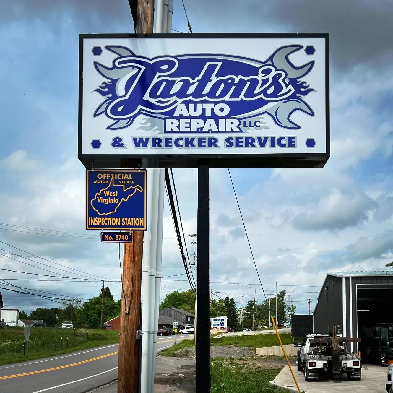 Taylor's Auto Repair and Wrecker Service roadside sign beside a highway under a cloudy sky