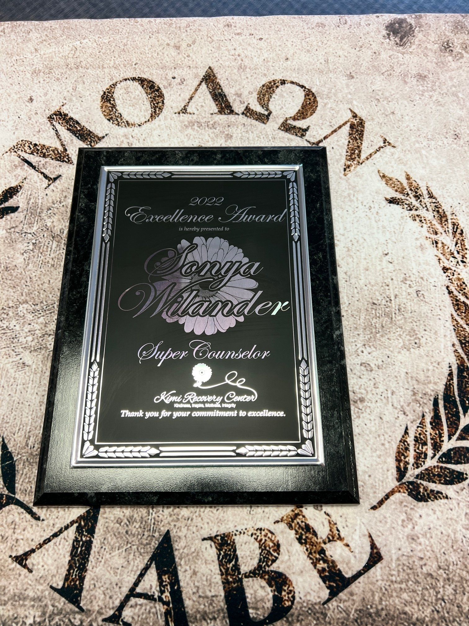 Award plaque on a patterned surface. It reads 