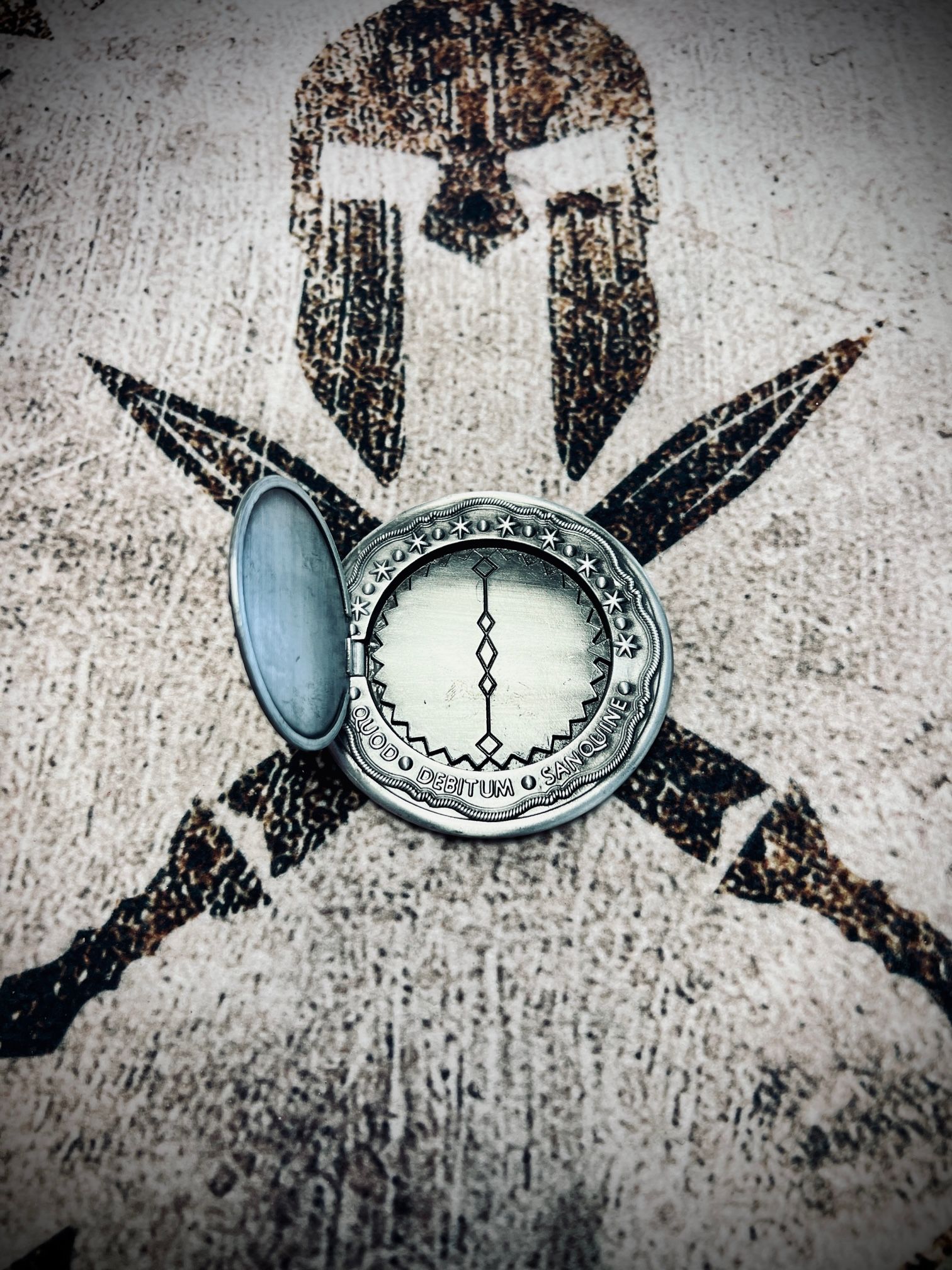 Stylized skull with crossed blades and a pocket watch on a textured gray background