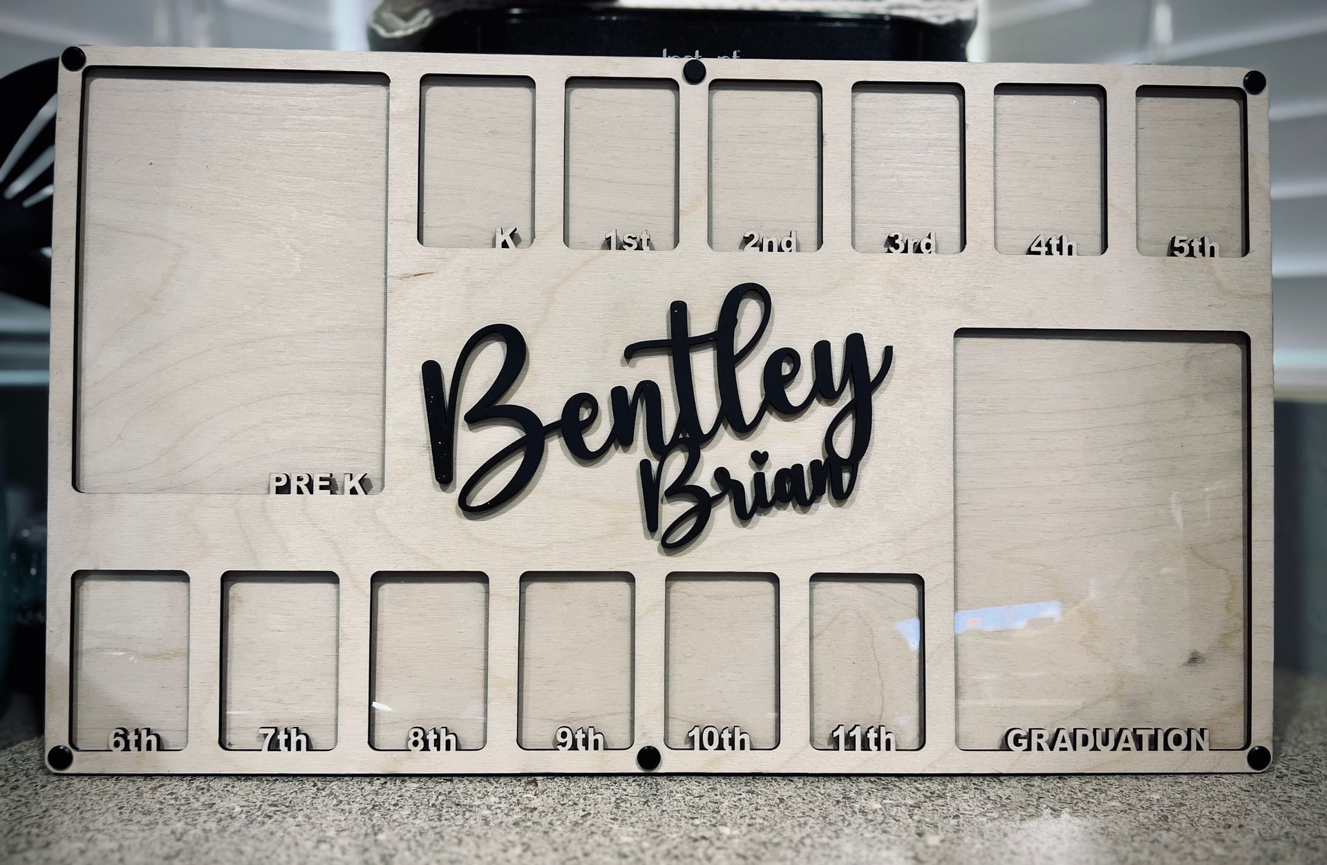 Bentley Brim logo on a beige display board with multiple rectangular cutouts and labeled slots