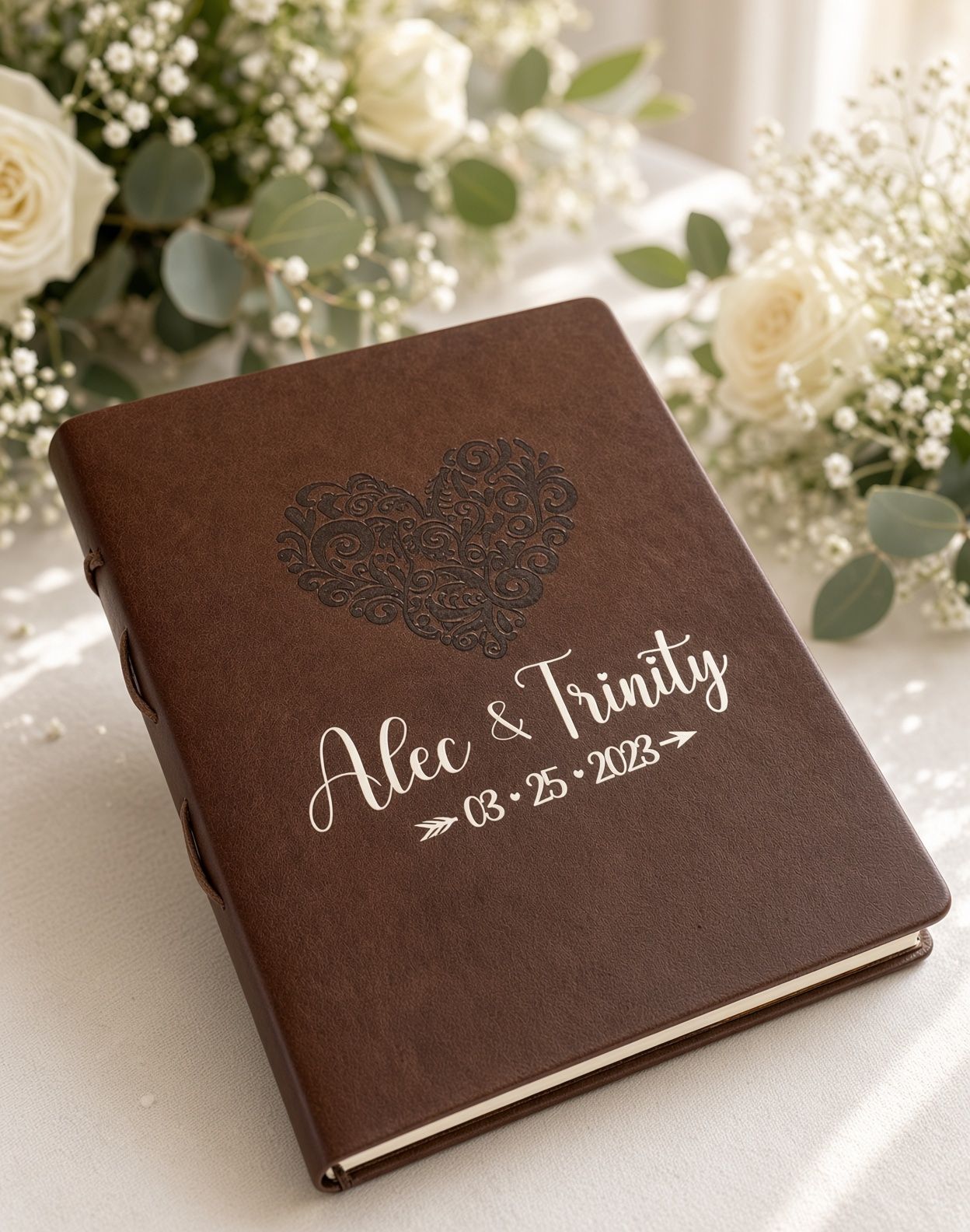 Brown leather-bound album with heart design and the names “Alex & Trinity” embossed on the cover.