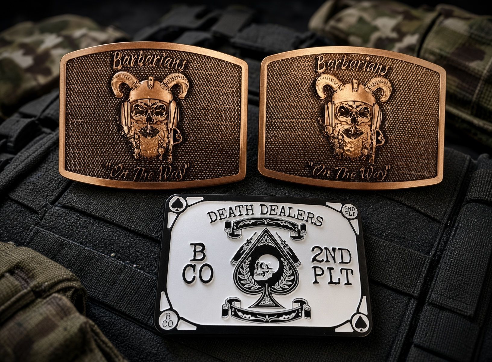 Three belt buckles: two bronze bear heads and one white 