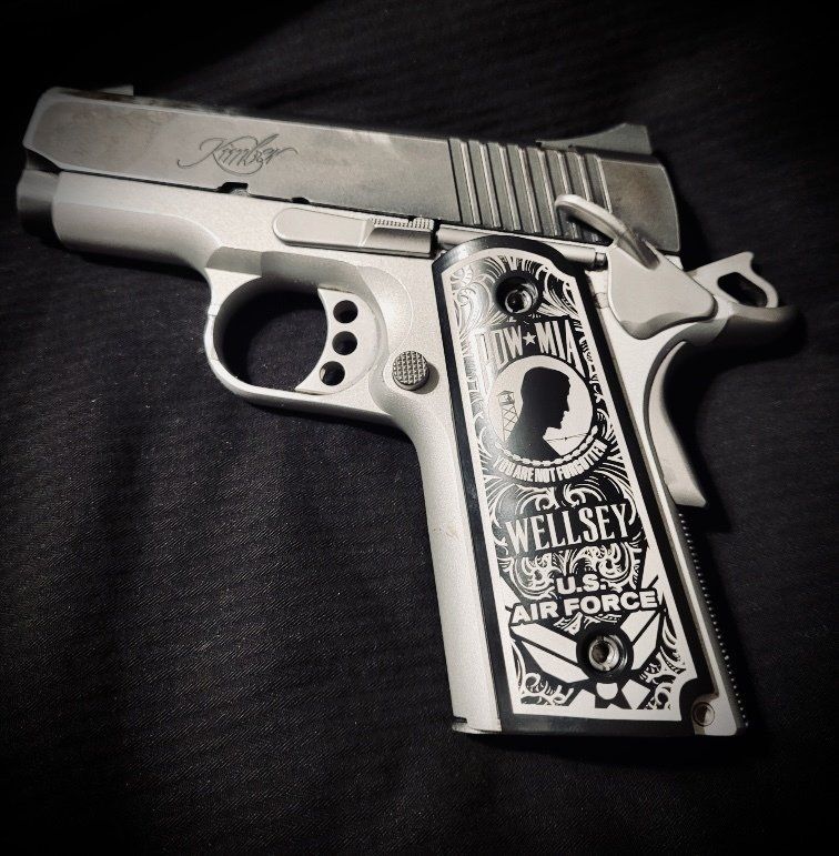 Kimber 1911 pistol with custom Air Force grips; gray and white with engraved details.