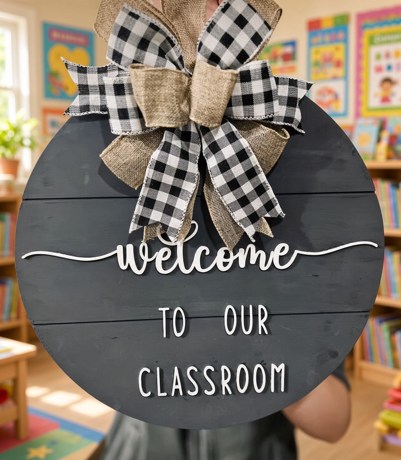 Black classroom sign with burlap and plaid bow reading “Welcome to our classroom.”